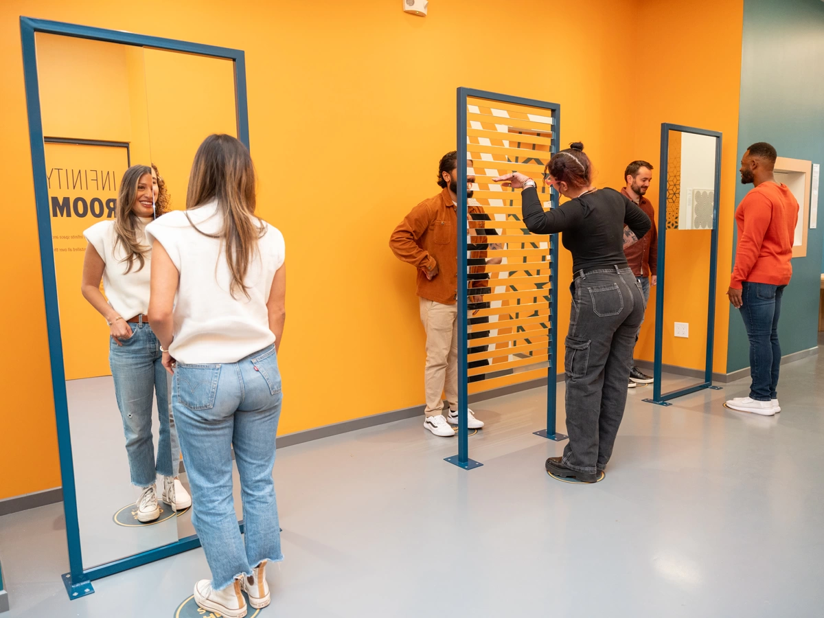 Three pairs of people interacting with Swap Noses and Swap Bodies installations at Museum of Illusions Denver.